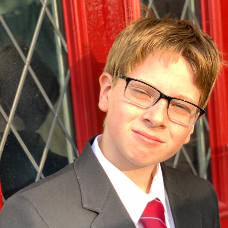 boy in secondary school uniform wearing glasses